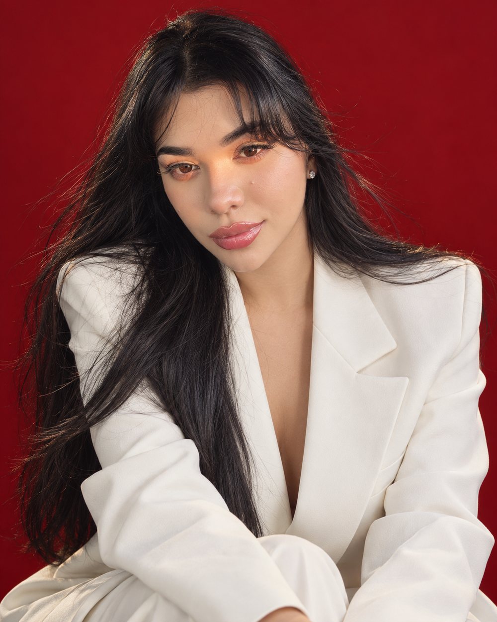 Retrato de la fundadora de Studio Scarlet con blazer marfil sobre fondo escarlata